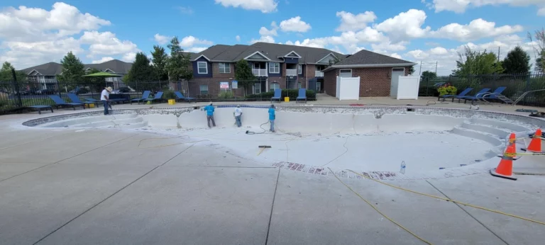 Commercial pool under renovation with workers resurfacing the interior