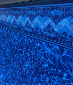 Close-up of a blue vinyl pool liner with decorative tile pattern
