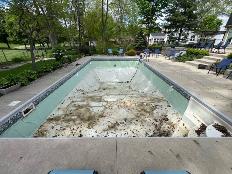 Vinyl liner replacement before photo - empty rectangular inground pool with damaged faded liner and debris needing replacement by Barton Pool Company