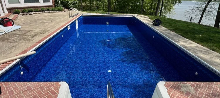 Residential pool renovation by Barton Pool Company - renovated rectangular inground pool with deep blue liner and brick paver deck