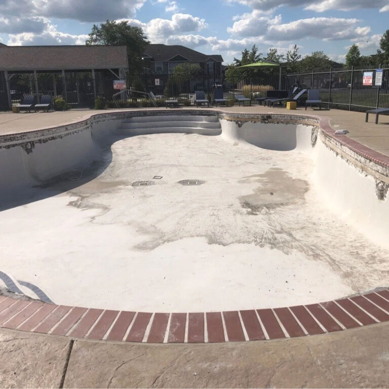 Pool renovation before photo - deteriorated inground pool with damaged surface and empty basin needing repair by Barton Pool Company