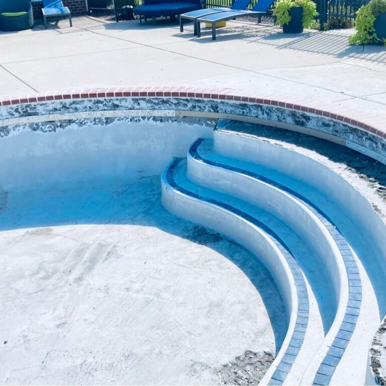 Pool renovation before photo - faded blue inground pool with worn steps and outdated tile requiring renovation by Barton Pool Company