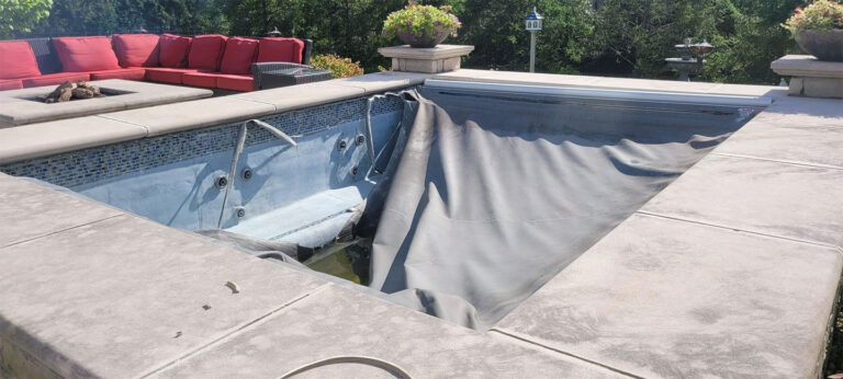 Pool renovation before photo - empty inground pool with old liner being removed and concrete deck by Barton Pool Company
