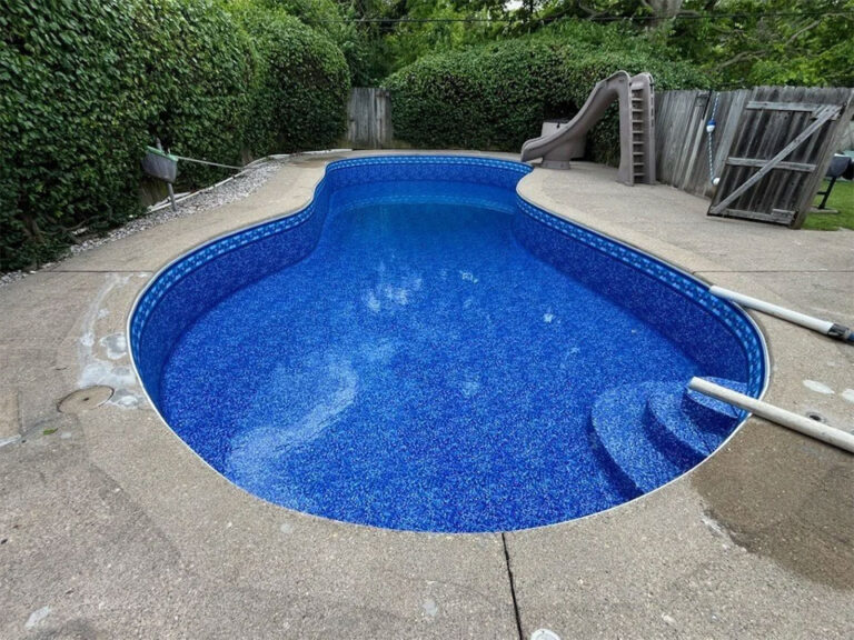 Pool vinyl liner replacement by Barton Pool Company - kidney-shaped inground pool with new blue patterned vinyl liner and concrete deck