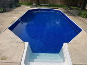 Octagon-shaped vinyl liner pool with entry steps and surrounding concrete deck