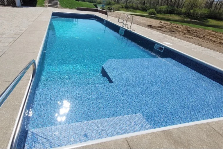 Vinyl liner pool with extended shallow platform and surrounding concrete deck
