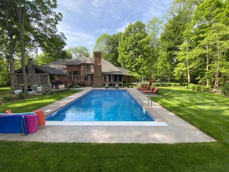 Vinyl liner pool with spacious concrete deck in a large shaded backyard