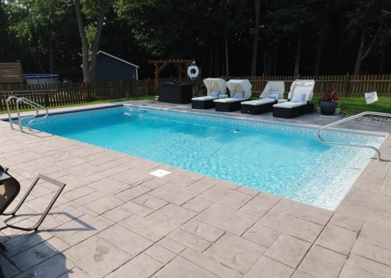 Vinyl liner pool with built-in tanning ledge, stamped concrete patio, and backyard seating